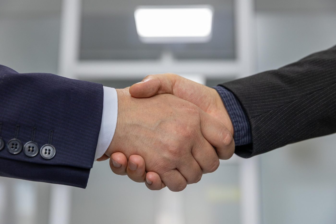 Two business people shaking hands after agreeing on financing for an electrical project